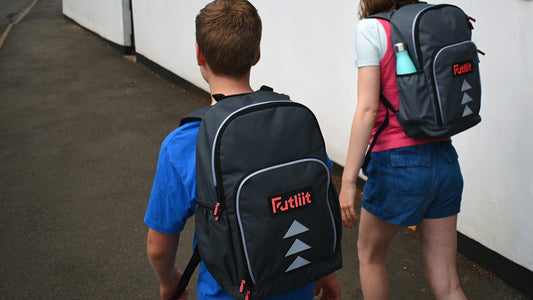 Two young people wearing Futliit LED backpacks